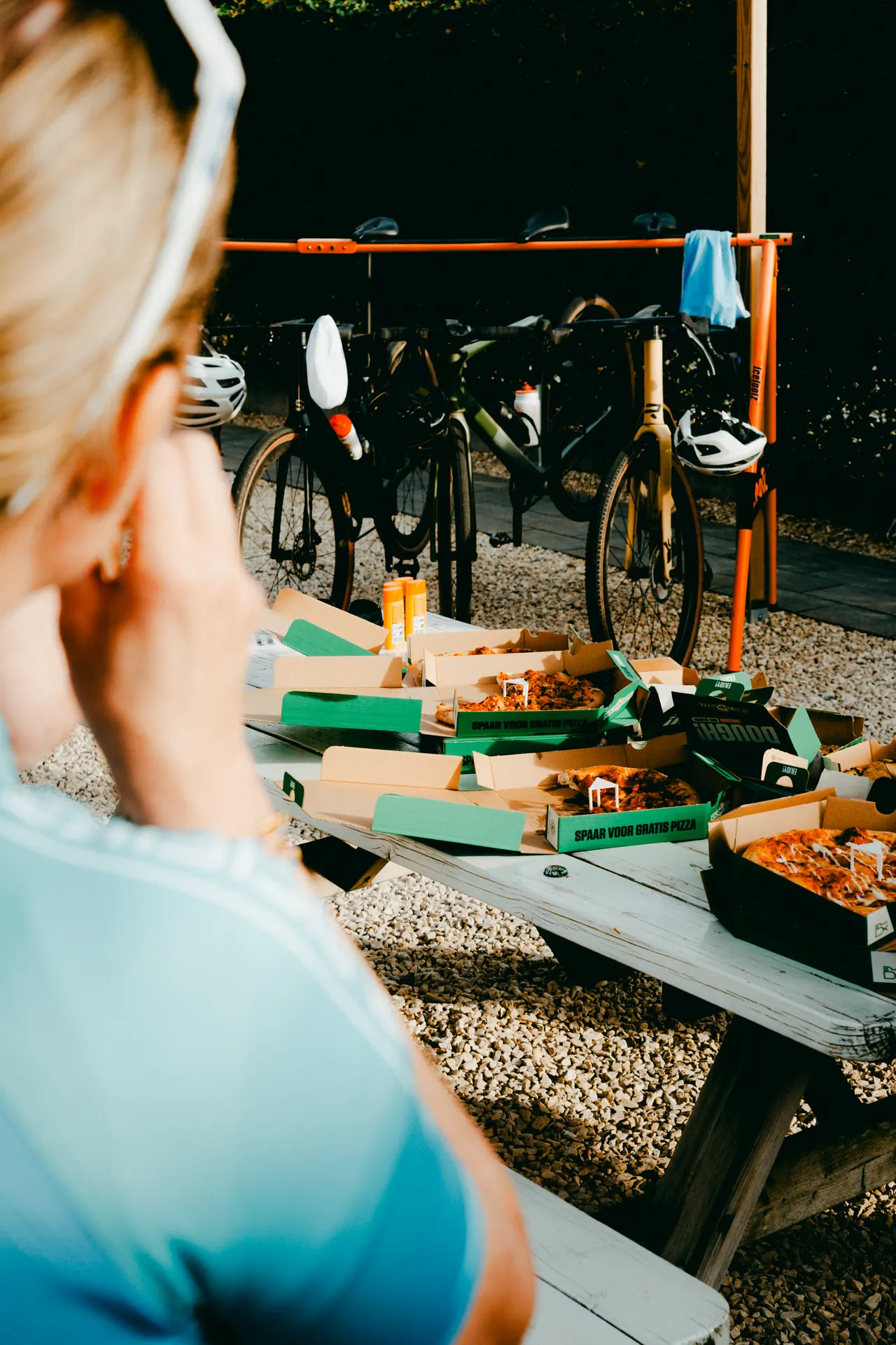 Fietsen bij een lange tafel waar rijders na afloop samen eten