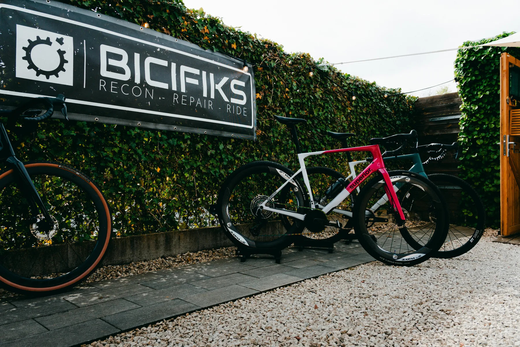 Fietsen klaar voor vertrek bij het Bicifiks-bord aan de werkplaats in Echt