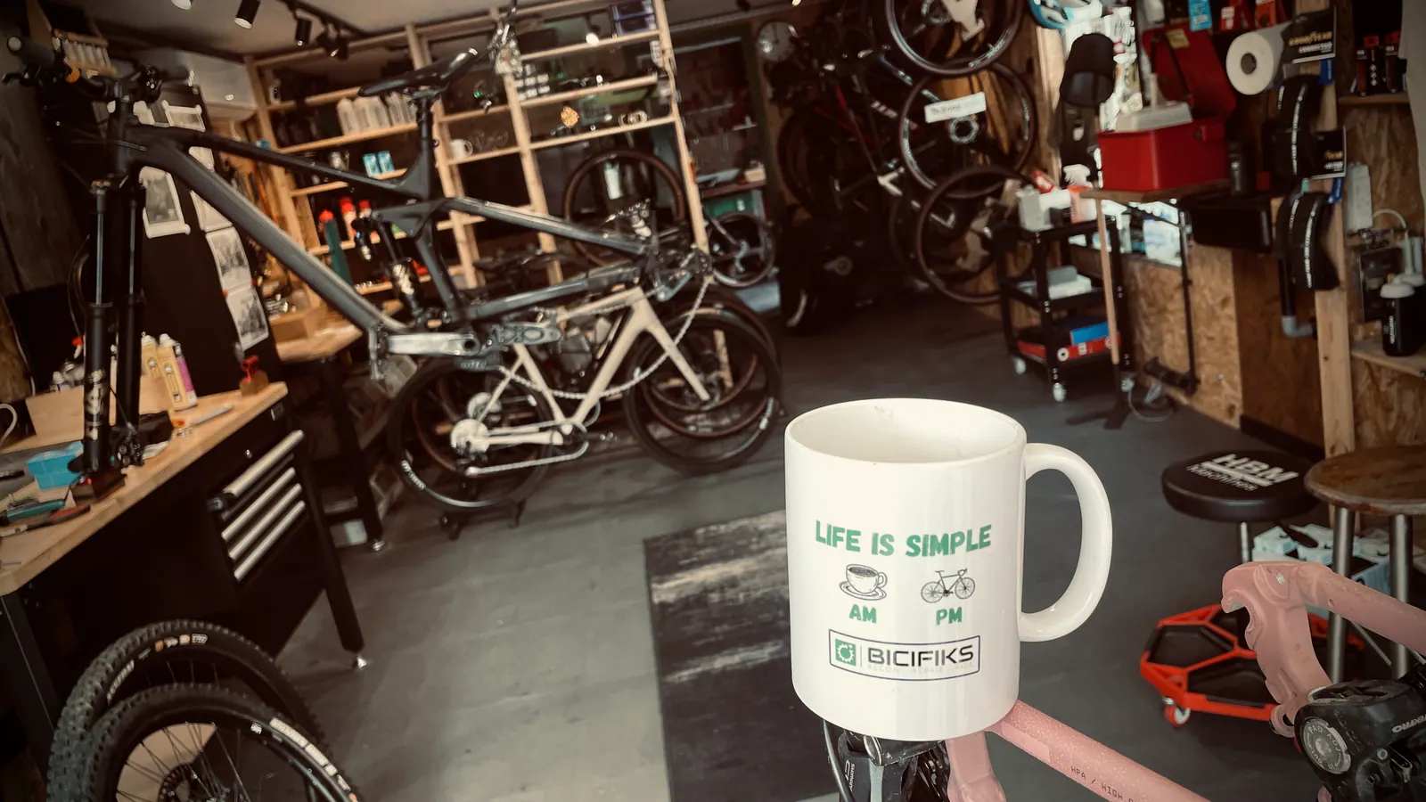 Koffie in het Bicifiks-atelier met fietsen en gereedschap op de achtergrond