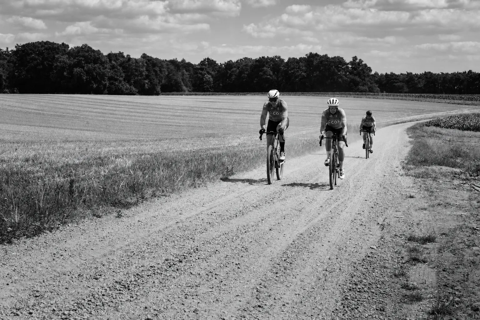 Drie gravelfietsers rijden over een landelijke gravelweg